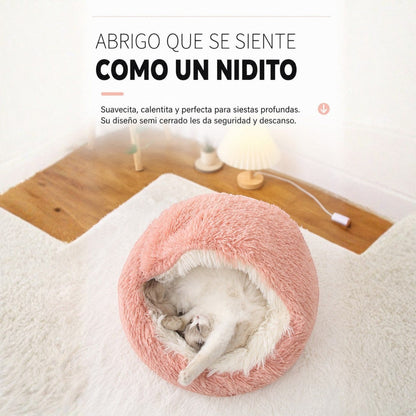 Cama antiestrés Purrfect Cozy Beds de felpa rosa tipo concha con un gato durmiendo cómodamente en su interior